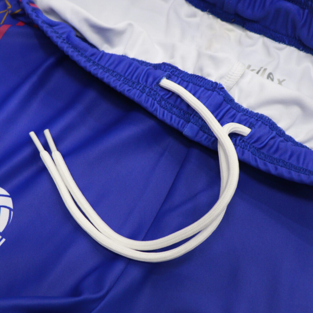 White drawstring and waistband detail on blue volleyball shorts