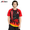 Model facing forward in a red and black shirt with lettering, a dinosaur head and yellow flame graphics.