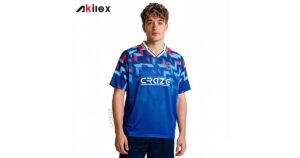Akilex custom sublimated blue soccer jersey with geometric sleeve print and V-neck collar, worn by a model