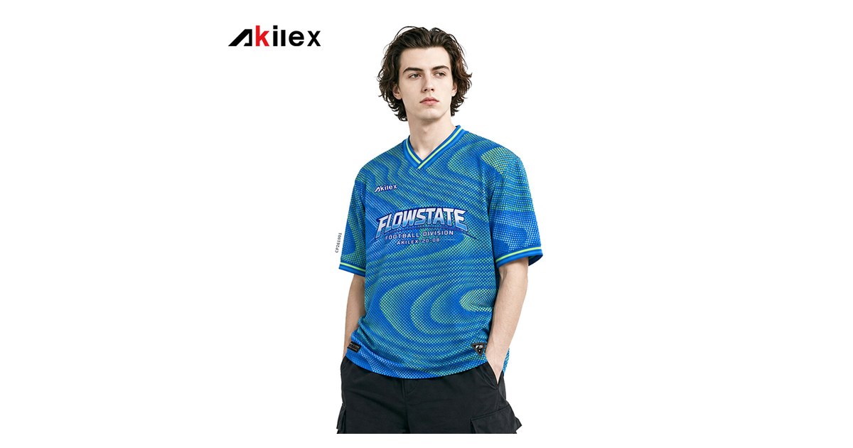 Akilex all-over dye-sublimated streetwear T-shirt with blue and green wave print, worn by a model